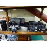 A collection of cameras including an Olympus OM1 camera in case and the matching Olympus [s83] WE DO