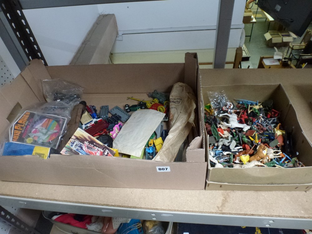 A mixed collection of die cast model vehicles, other toys, and model cowboys, soldiers and