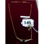 A 9 ct gold necklet set with a dark stone and two tiny diamonds, and a pair of 9 ct earrings set