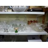 Two shelves of glassware including two orange carnival glass bowls, two decanters and stoppers, wine