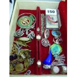 A cream jewel box containing silver and other costume items, including three 1960s brooches by