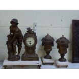 An early 20th century French garniture in spelter and cream marble, the mantel timepiece with a