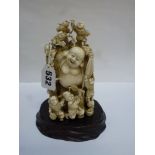 A good Japanese carving, Meiji period, of Hotei and a crowd of playful children, signed on red