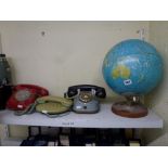 A vintage table globe, three vintage telephones including FTR dial phone and another in red, plus