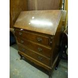 A mid century walnut bureau above three drawers and a walnut cocktail cabinet enclosed by a pair