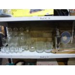 Three shelves of mixed items including a soda syphon, cocktail shaker, three matching crystal