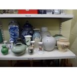 A shelf of pottery vases and jars plus a blue and white egg ornament, two pairs of china