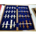 An Eastern figural chess set in carved natural and stained bone, in wooden fitted games board box [