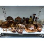 A shelf of wooden wares including serving bowls, carved elephant and tiger figurines, boxes and
