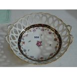 A Chelsea Derby porcelain circular pierced basket painted with a rose sprig within a swagged floral,