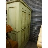 A charming Continental wardrobe, circa 1900, painted green with gilt highlights, the two panelled