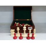An antique carved chess set, red stained and natural, max height 9 cm, in mahogany box [J] WE DO NOT