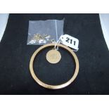 9 ct gold comprising: a hollow bangle, circular locket with internal photograph under glass, a