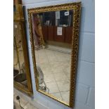 A rectangular gilt framed dressing mirror and an oval gilt framed mirror with scrolling