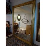 A gilt rectangular bevelled framed mirror and a wooden framed bevel edged mirror with plaited
