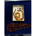 An old amber necklace of irregular beads, in varying butterscotch tones, a similar plaque and bead