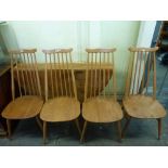 An Ercol drop-flap dining table forming a circle and four stick back chairs in light beech. WE DO