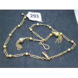 A very decorative Victorian watch chain in 15 ct gold, of fetter and ball links, hung with two