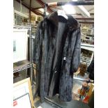 A lady's dark brown mink fur full-length coat with shawl collar, gathered cuffs with leather bow