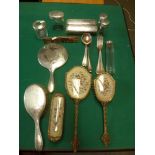 An early George V silver dressing table set of hand mirror and three brushes, delicately engraved,