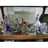 A shelf of mainly figurines including white-glazed figural and bird ornaments, a Nao clown, three