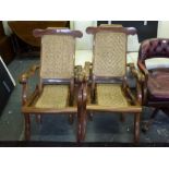 A pair of hardwood steamer chairs with rattan seats and backs. WE DO NOT ACCEPT CREDIT CARDS.