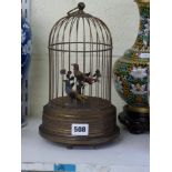 A 20th century singing bird automaton, the brass wire cage containing two perched birds with