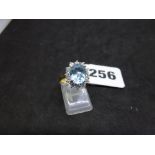 A modern aquamarine and diamond cluster ring in 18 ct yellow gold, with white claw settings, the