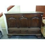 An impressive 18th century oak mule chest the hinged lid above three-panelled front and three