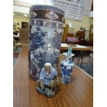 A large blue and white gilt-decorated umbrella stand, a blue and white vase and a pottery figurine