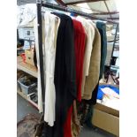 A part rail of vintage clothing including a 1950s tennis dress, 1960s and 1970s gowns, an