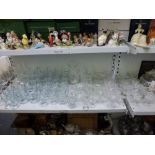 A shelf of glassware including red and white wine glasses, champagne saucers, sherry glasses,