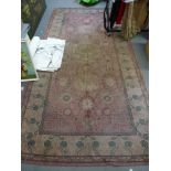 A machine-made rug in shades of pink with Eastern decoration, 9 ft 6 in x 5 ft approx. [floor at top