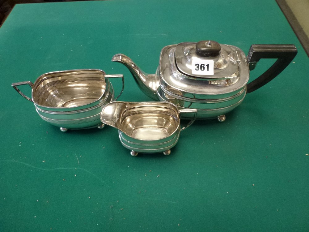 An early George V silver three-piece tea set in Regency style, on bun feet with black handle and