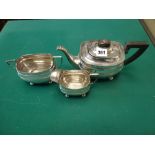 An early George V silver three-piece tea set in Regency style, on bun feet with black handle and