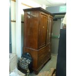 An early 19th century mahogany linen press the pair of panelled doors enclosing six slides above two