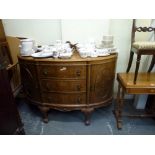 A good quality mid-20th century walnut sideboard of demi-lune form the three central drawers flanked