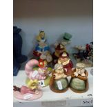 Nine Royal Doulton Alice in Wonderland figurines including Alice, Mad Hatter, Tweedledum and