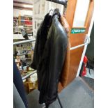A ladies' black leather coat with fur lining and a tan leather jacket with stitching detail [