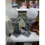 A pair of stylish metal Art Deco-style table-lamps modelled as seat ladies holding globes. [s72]