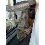 A stone bird bath modelled as a cherub holding a dish above and a stone column bird bath. WE DO
