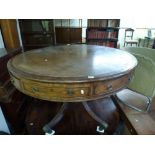 A George IV mahogany revolving drum table, with a green tooled leather top above four drawers