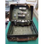 An Edwardian dark green leather dressing case, retaining various silver fittings, including three