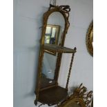 A late Victorian gilt two-tier hanging shelf, with mirror back and column supports. WE DO NOT ACCEPT