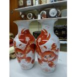 A pair of Oriental porcelain vases painted with Buddhistic lions in iron red, 28 cm [Q] WE DO NOT