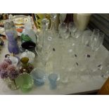An interesting selection of glass items that includes drinking vessels, decanters and stoppers,