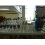 Two shelves of glassware including a set of six smoky glass sundae glasses, a pair of smoky glass