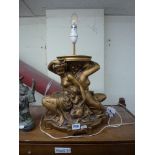 A large gold-painted plaster table-lamp figured as two women holding a child. [on top of s83] WE