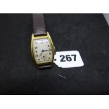 A vintage man's wrist watch, in 18 ct gold tonneau case, movement and dial unsigned, the case with