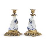 A PAIR OF JAPANESE WHITE AND BLUE PORCELAIN CANDLESTICKS 19TH CENTURY. DEFECTS.